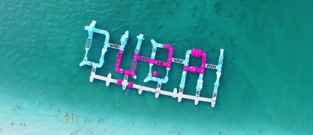 Aerial shot of AquaFun Dubai spelling out 'Dubai' with JBR skyline in the background