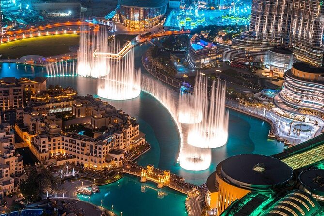 A stunning view of The Dubai Fountain's water jets illuminated by colorful lights against the night sky