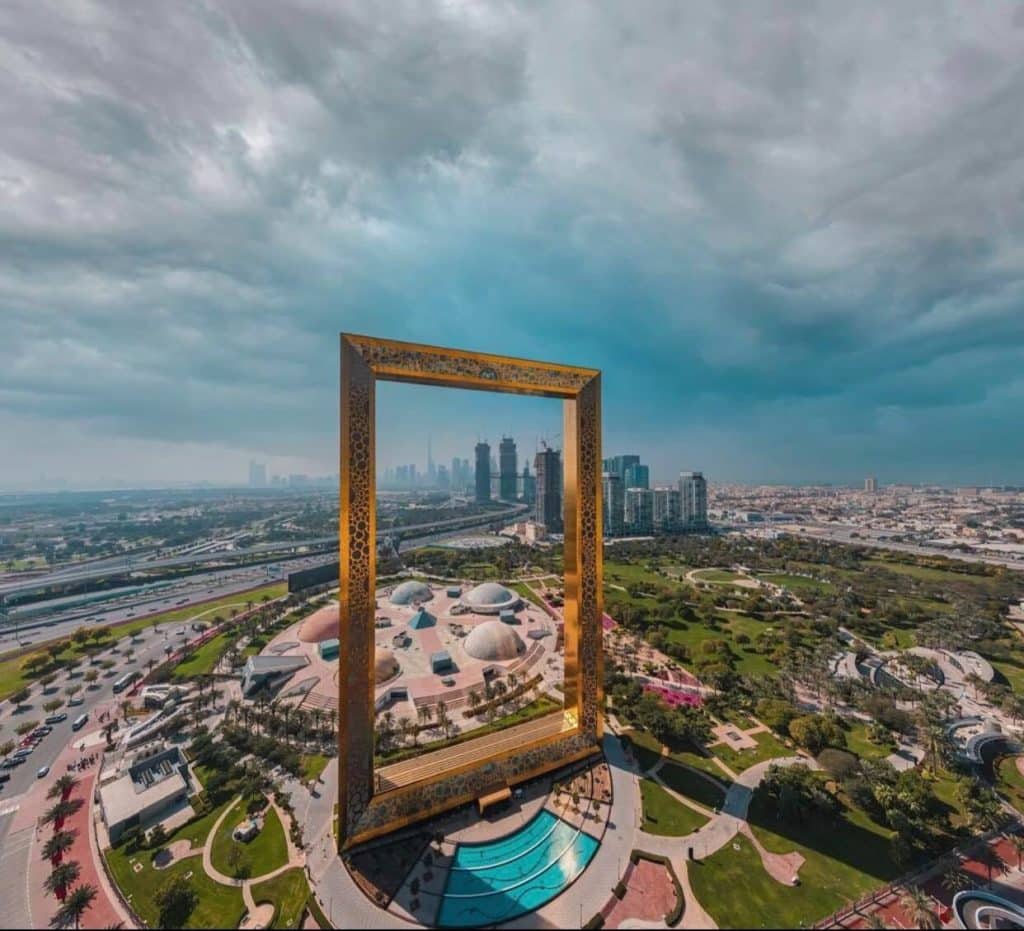 A close-up view of the Sky Deck of the Dubai Frame, with visitors walking on the transparent glass bridge.